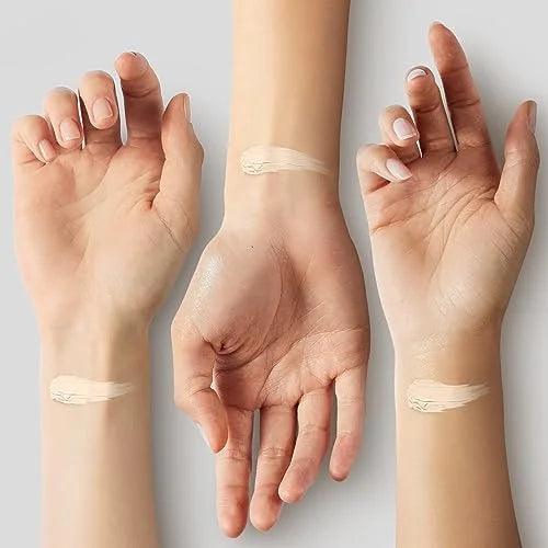 Three hands with cosmetic cream application on a neutral background