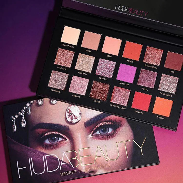Huda Beauty makeup palette with color swatches on a pink and purple gradient background