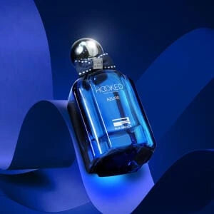 Blue perfume bottle with silver cap on a blue background