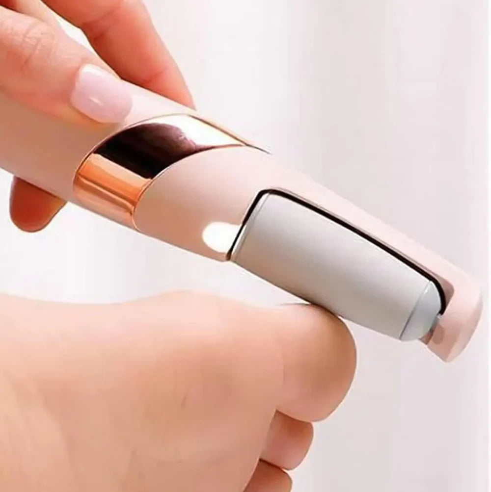 Hand holding a small electronic device with a rose gold and silver design on a white background